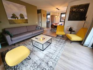 a living room with a couch and chairs and a table at New 3 bedroom house 7 people in Ewijk