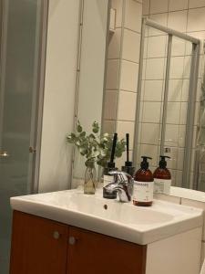 a bathroom sink with a mirror and flowers on it at Lovely two bedroom flat in central Oslo in Oslo