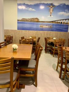 uma sala de jantar com mesas e cadeiras de madeira em Hotel Grutta em Bom Jesus da Lapa