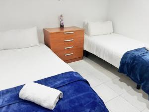 1 dormitorio con 2 camas y tocador de madera en Acogedor Apartamento, en Hospitalet de Llobregat