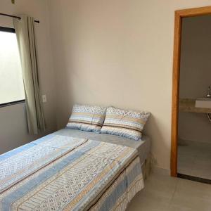 uma cama com duas almofadas num quarto em Mig 1 em Pirenópolis