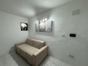 un divano in una stanza con due foto sul muro di Civico 8 a Sassari