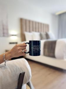 Een vrouw houdt een koffiemok vast met haar hand. bij Meson del Valle in Zamora de Hidalgo