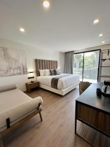 um grande quarto de hotel com duas camas e um sofá em Meson del Valle em Zamora de Hidalgo