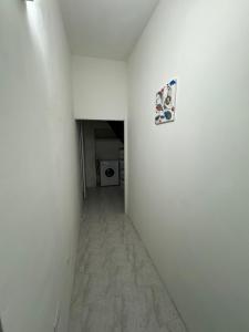 un corridoio vuoto con parete bianca e lavanderia di Civico 8 a Sassari