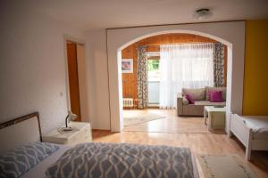 ein Schlafzimmer mit einem Bett und ein Wohnzimmer in der Unterkunft Gasthaus zum Odenwald 