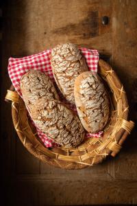 three pieces of bread in a basket on a table at Gasthaus zum Odenwald 