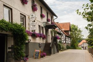 un edificio con fiori sul lato di una strada di Gasthaus zum Odenwald a Schannenbach