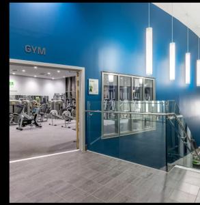 a gym with a blue wall and tread machines at Etihad Stadium, Coop Live Arena Manchester in Manchester