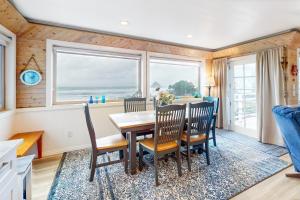 a dining room with a table and chairs and windows at Wave Watch `N in Oceanside