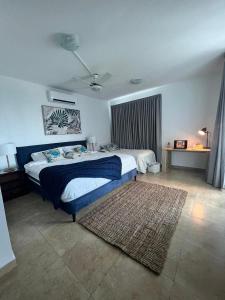 1 dormitorio con 1 cama con manta azul y alfombra en Playa Blanca Edificio Founders 3, en Playa Blanca