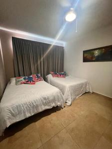 two beds in a room with a window at Playa Blanca Edificio Founders 3 in Playa Blanca +25 photos
