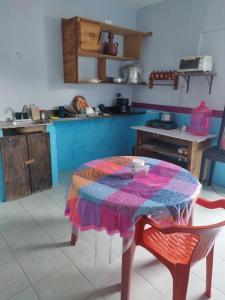 een keuken met een tafel en een quilt bij Hostal y Temazcal Guemez in Pisté