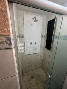uma casa de banho com um chuveiro e uma porta de vidro em Boa Viagem Flat no Recife