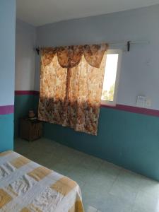 1 dormitorio con cama y ventana en Hostal y Temazcal Guemez en Pisté