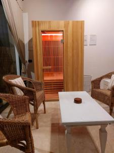 - un salon avec une table et des chaises blanches dans l'établissement Residenza Porta Rossa con spa privata, à Montegabbro