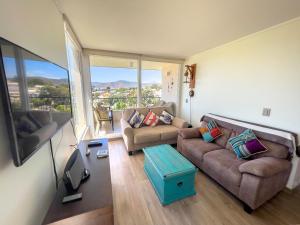 una sala de estar con 2 sofás y una ventana grande en Disfruta Papudo: comodidad y cercanía a la playa, en Papudo