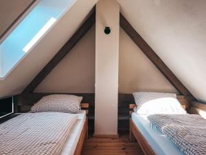 two beds in a attic room with a window at Kyritzer Budenhaus (Nr. 107) in Kyritz