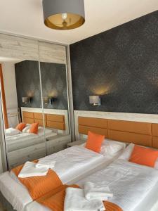 two beds in a bedroom with orange pillows at Pensjonat Latino in Rowy