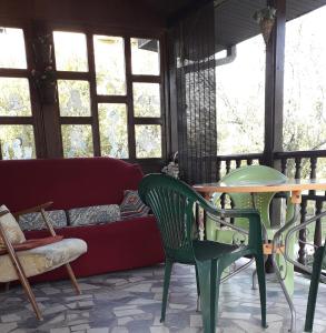 a living room with a couch and a table and chairs at Kuca za odmor Zicanka in Kraljevo