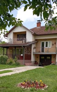a house with a balcony and a yard at Kuca za odmor Zicanka in Kraljevo