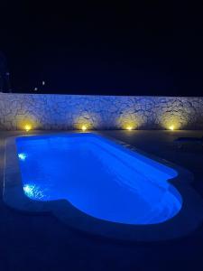 una piscina azul por la noche con luces en Villa Zara, en Poreč