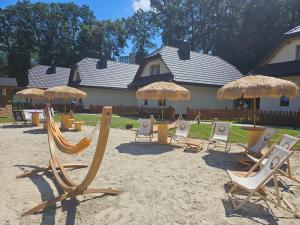 un gruppo di sedie e ombrelloni in spiaggia di Osada Słoneczny Zdrój a Rymanów-Zdrój