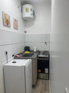 a small kitchen with a stove and a refrigerator at Departamento moderno, equipado full en vicente López ,ubicacion inmejorable a 100 metros del tren in Florida +6 photos