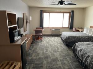 Cette chambre comprend deux lits et une télévision. dans l'établissement Great Northern Motel, à Mercer