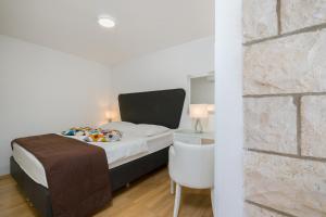 um pequeno quarto com uma cama e uma parede de tijolos em Apartment Cable car 1 em Dubrovnik