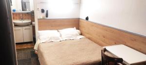 サン・トゥアンにあるオテル レジデンス サン トゥアンの小さなベッドルーム(シンクとテーブル付きのベッド付)