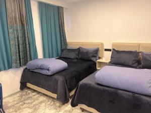 イスタンブールにあるPark View 201 double roomの緑のカーテンが備わる客室のベッド2台