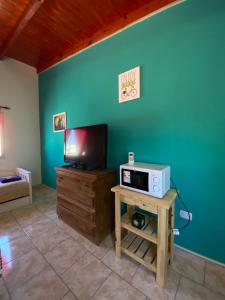 sala de estar con TV y mesa con microondas en CATALINA en Neuquén