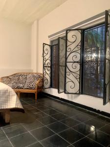 タスコ・デ・アラルコンにあるCasaBambu Taxcoのシマウマのプリントチェアと窓が備わる客室です。