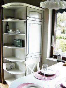 a kitchen with a table and a white refrigerator at FEWO Schlei-Hering bei Kappeln Ostsee in Oersberg