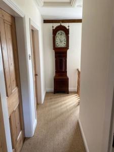 a hallway with a grandfather clock in a room at The Bolt Hole, Cotswold Cottage, Moreton-In-Marsh in Moreton in Marsh