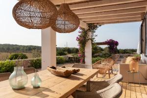 een patio met een houten tafel en stoelen bij Somnis in La Mola