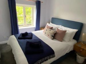 a bedroom with a large bed with pillows and a window at The Bolt Hole, Cotswold Cottage, Moreton-In-Marsh in Moreton in Marsh