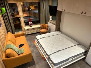 Habitación con cama, sofá y silla en TIGNES VAL CLARET A LA CONQUETE DES SOMMETS MOUTIERE B23 en Tignes
