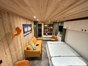 Habitación pequeña con cama y sofá en TIGNES VAL CLARET A LA CONQUETE DES SOMMETS MOUTIERE B23 en Tignes