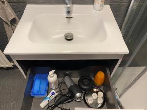 un lavabo blanco bajo la encimera del baño con un cajón en studio CHEZ TONY, en Luxemburgo