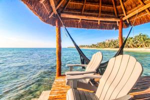dos sillas sentadas en un muelle junto al océano en Villa Tankah 7 Cielo en Tulum