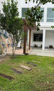 a building with a tree in the yard at Residencial Vilaça in Guarapari