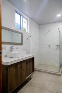 y baño blanco con lavabo y ducha. en Casa Campo Victoria, en Valledupar