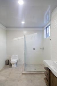 y baño blanco con aseo y ducha. en Casa Campo Victoria, en Valledupar