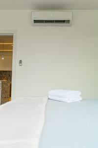 uma cama com lençóis brancos e toalhas em Luxury Apartments estilo New York em Guayaquil