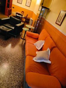um sofá laranja com duas almofadas na sala de estar em Ca La Solé em Vinarós