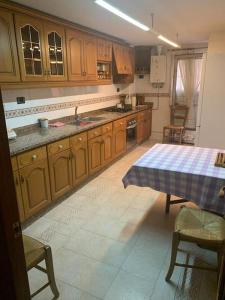 uma cozinha com armários de madeira e uma mesa com uma toalha de mesa em Ca La Solé em Vinarós