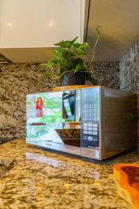 a microwave sitting on a counter with a potted plant at Luxury Apartments estilo New York in Guayaquil