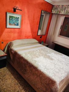 um quarto com uma cama grande e paredes cor-de-laranja em Ca La Solé em Vinarós